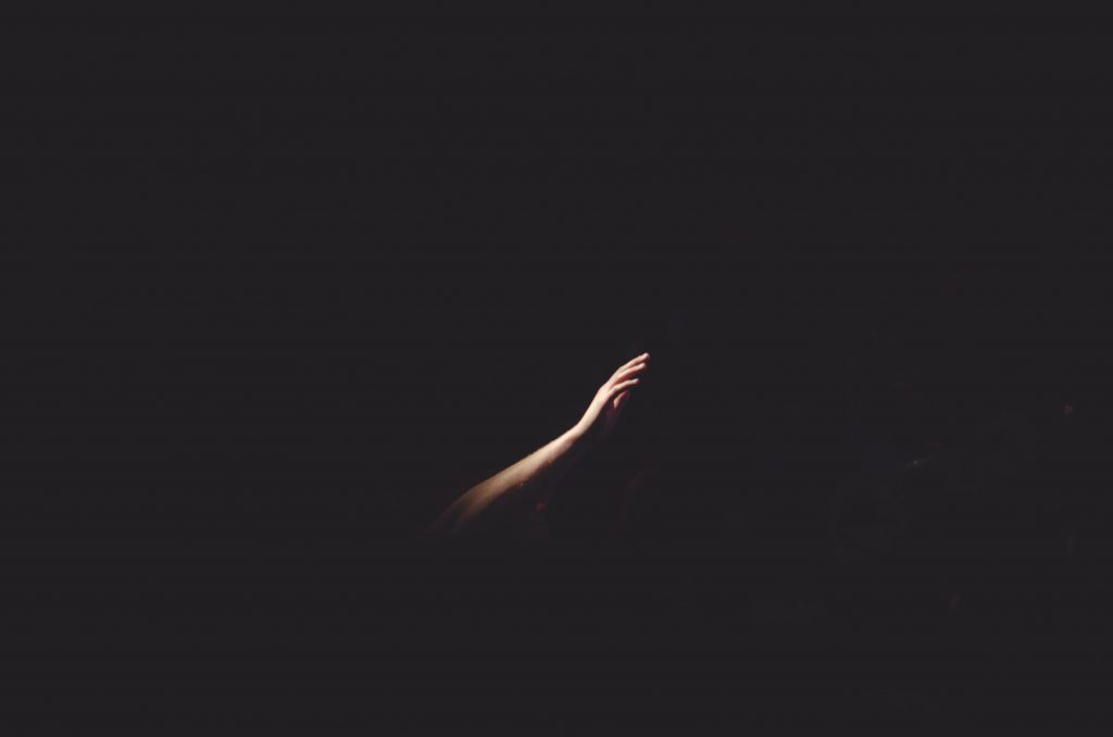 Hand reaching out in darkness